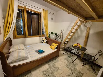 a small bedroom with a bed and a staircase at Beau studio en centre ville in Narbonne