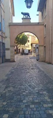 a person walking down a cobblestone street at Beau studio en centre ville in Narbonne