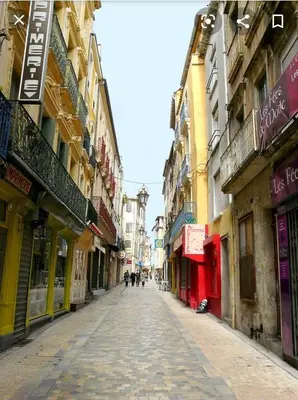 an empty street in a city with many buildings at Beau studio en centre ville in Narbonne