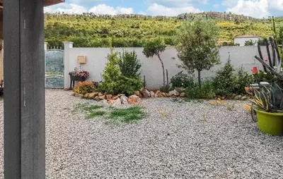 a garden with rocks and plants in front of a wall at 2 Bedroom Cozy Home In Saint Chinian in Saint-Chinian