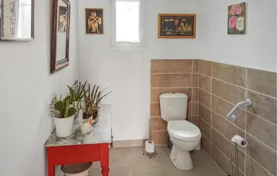 a bathroom with a toilet and plants on a counter at 2 Bedroom Cozy Home In Saint Chinian in Saint-Chinian