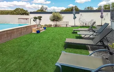a yard with lounge chairs and a swimming pool at 2 Bedroom Cozy Home In Saint Chinian in Saint-Chinian