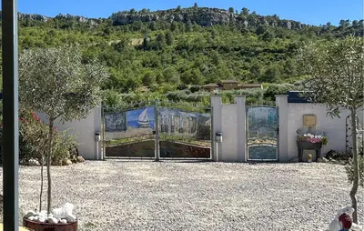 a building with a gate with a mountain in the background at 2 Bedroom Cozy Home In Saint Chinian in Saint-Chinian