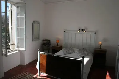 a bedroom with a bed and a window at Character filled house overlooking the River Cesse in Bize-Minervois
