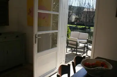 a door leading to a patio with a bowl of fruit on a table at Character filled house overlooking the River Cesse in Bize-Minervois