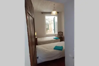 a small room with two beds and a window at Character filled house overlooking the River Cesse in Bize-Minervois