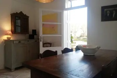 a dining room with a wooden table and a window at Character filled house overlooking the River Cesse in Bize-Minervois