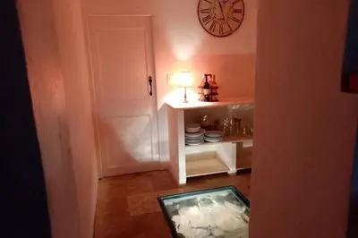 a room with a clock on the wall and a table at Character filled house overlooking the River Cesse in Bize-Minervois