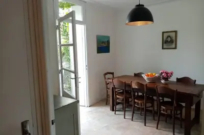 a dining room with a wooden table and chairs at Character filled house overlooking the River Cesse in Bize-Minervois
