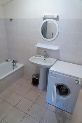 a bathroom with a washing machine and a sink at Gîte Mairie in Fosse