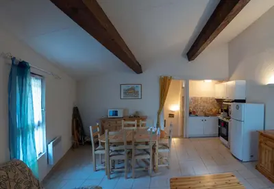 a kitchen and dining room with a table and chairs at Gîte Mairie in Fosse