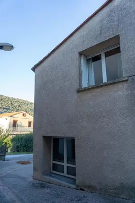 a building with two windows on the side of it at Gîte Mairie in Fosse