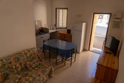 a living room with a couch and a table in a kitchen at Gîte La Place in Fosse