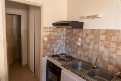 a kitchen with a sink and a stove top oven at Gîte La Place in Fosse
