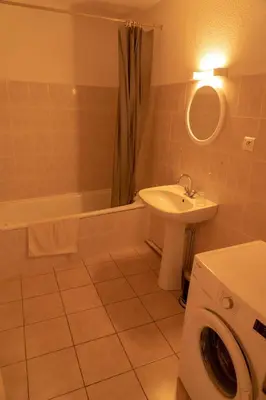 a bathroom with a sink and a washing machine at Gîte La Place in Fosse