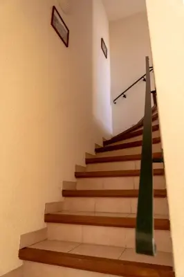 a staircase with a green column in a building at Gîte La Place in Fosse