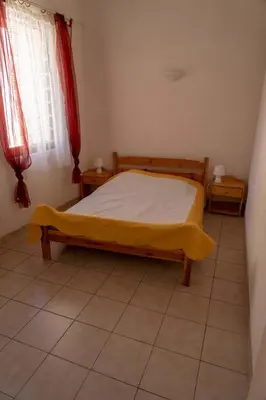 a bedroom with a bed with a yellow blanket on it at Gîte La Place in Fosse