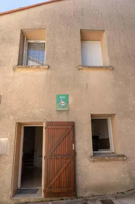 a building with a wooden door and two windows at Gîte La Place in Fosse