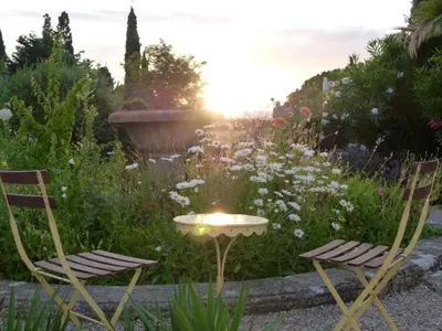 two chairs and a table in a garden at Château De Massignan in Saint-Marcel