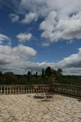 a bench sitting on a stone patio under a cloudy sky at Château De Massignan in Saint-Marcel