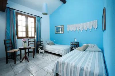 a blue bedroom with a bed and a table and chairs at Château De Massignan in Saint-Marcel