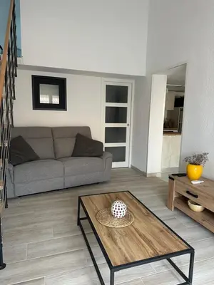 a living room with a couch and a table at New Maison tout confort, bord de mer avec Parking Privé in Gruissan