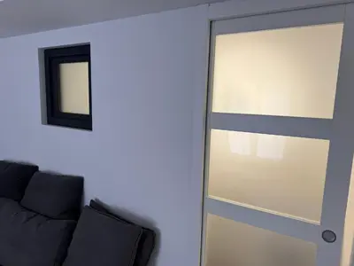 a sliding glass door in a room with a couch at New Maison tout confort, bord de mer avec Parking Privé in Gruissan