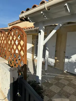 a wooden gate in front of a house at New Maison tout confort, bord de mer avec Parking Privé in Gruissan