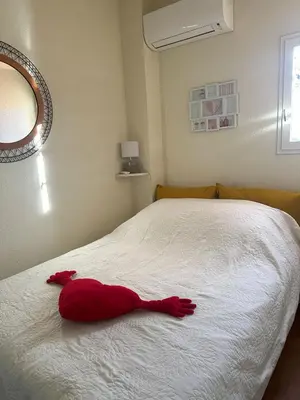 a red stuffed animal laying on a bed at New Maison tout confort, bord de mer avec Parking Privé in Gruissan