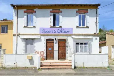 a white house with a sign on the front of it at COMME A LA MAISON in Espéraza