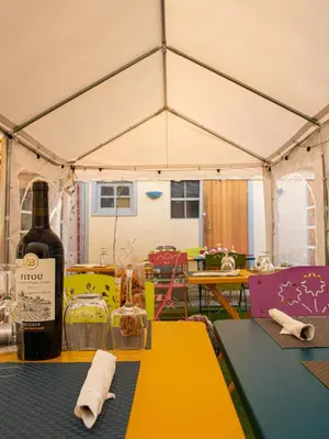 a bottle of wine sitting on a table in a tent at COMME A LA MAISON in Espéraza