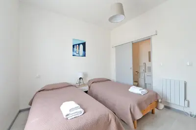 two beds in a room with white walls at COMME A LA MAISON in Espéraza