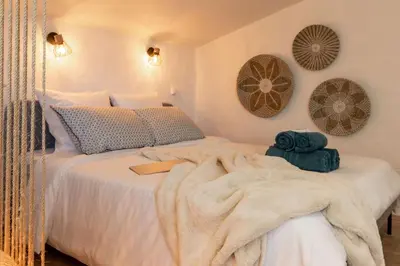 a bedroom with a bed with a blanket on it at Le Boheme - Netflix - Wifi - Vue sur la Cité Médiévale et les toits in Carcassonne