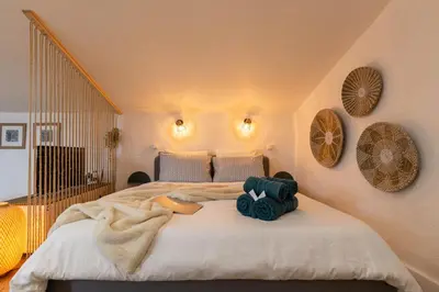 a bedroom with a large bed with towels on it at Le Boheme - Netflix - Wifi - Vue sur la Cité Médiévale et les toits in Carcassonne