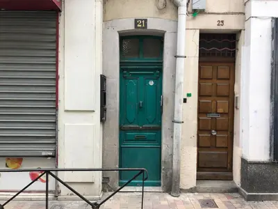 a green door on the side of a building at Le Boheme - Netflix - Wifi - Vue sur la Cité Médiévale et les toits in Carcassonne