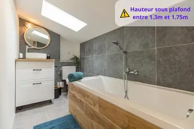 a bathroom with a bath tub and a sink at Le Boheme - Netflix - Wifi - Vue sur la Cité Médiévale et les toits in Carcassonne