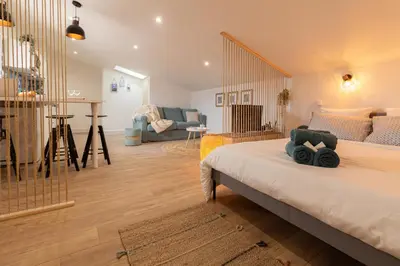 a bedroom with a bed and a living room at Le Boheme - Netflix - Wifi - Vue sur la Cité Médiévale et les toits in Carcassonne