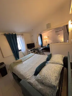 a bedroom with a bed and a desk in a room at LE CORS’HALLES in Narbonne