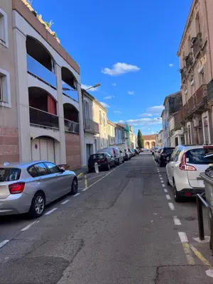 a street with cars parked on the side of the road at LE CORS’HALLES in Narbonne