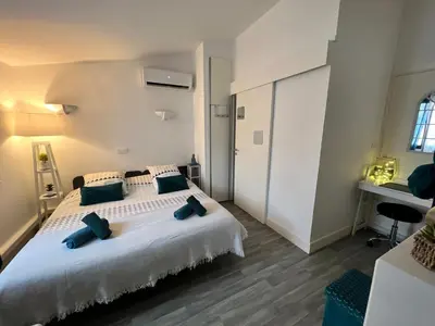 a bedroom with a large white bed with blue pillows at LE CORS’HALLES in Narbonne