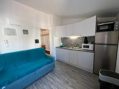 a living room with a blue couch in a kitchen at LE CORS’HALLES in Narbonne