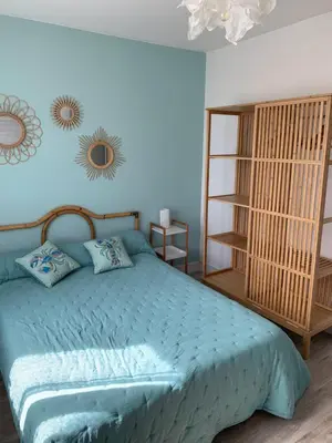 a bedroom with a bed with a blue comforter at Appartement la corde a linge Gruissan village avec terrasses in Gruissan