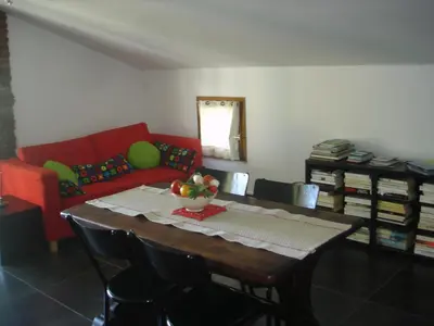 a living room with a table and a red couch at Location gîte 4 personnes Mazères - La Petite Maison in Mazères