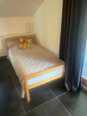a small bed in a small room with aermottermottermott at Location gîte 4 personnes Mazères - La Petite Maison in Mazères