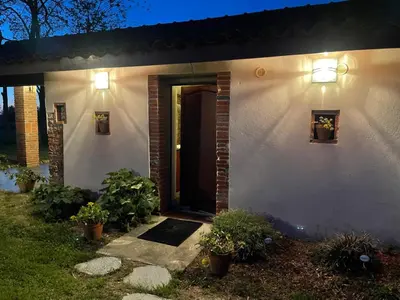 a white house with a door and lights on it at Location gîte 4 personnes Mazères - La Petite Maison in Mazères