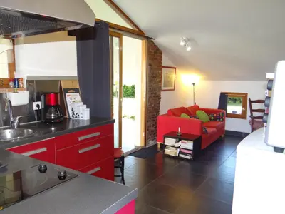 a kitchen and living room with a red couch at Location gîte 4 personnes Mazères - La Petite Maison in Mazères