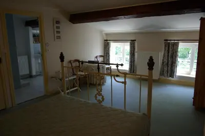 a bedroom with a bed and a chair in it at L'Impasse du Temple in Léran