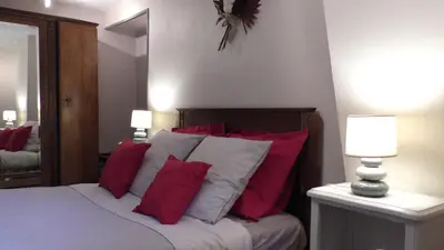 a bedroom with a bed with red and white pillows at Gîte Roc Suzadou in Ferrals-les-Montagnes