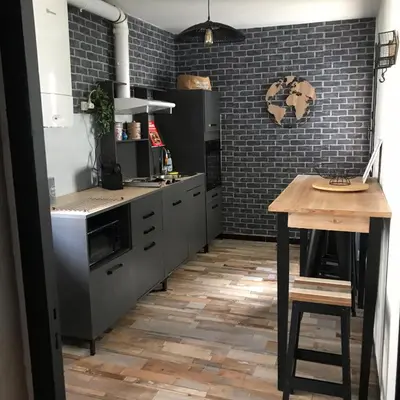 a kitchen with gray appliances and a wooden table at MARINA 2 in Narbonne