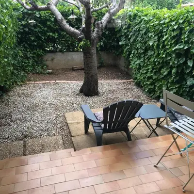 a patio with two chairs and a tree at MARINA 2 in Narbonne